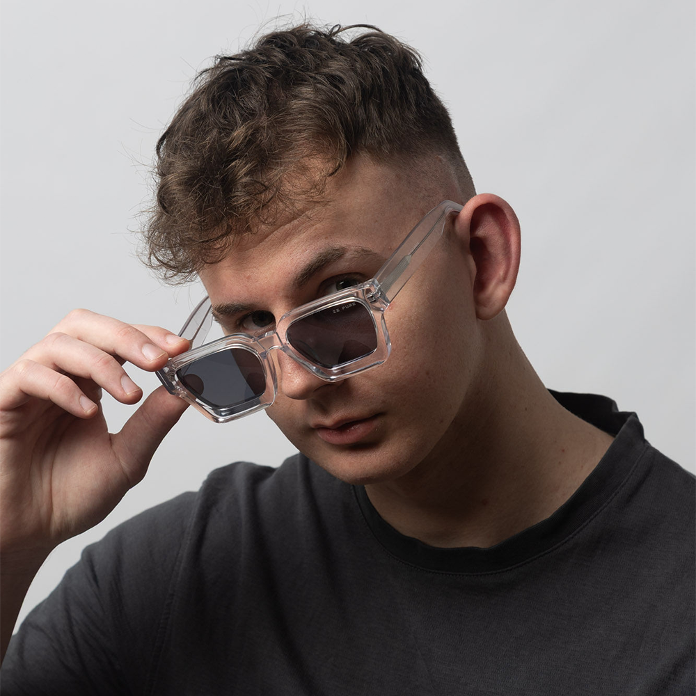 Person wearing clear sunglasses with a neutral background