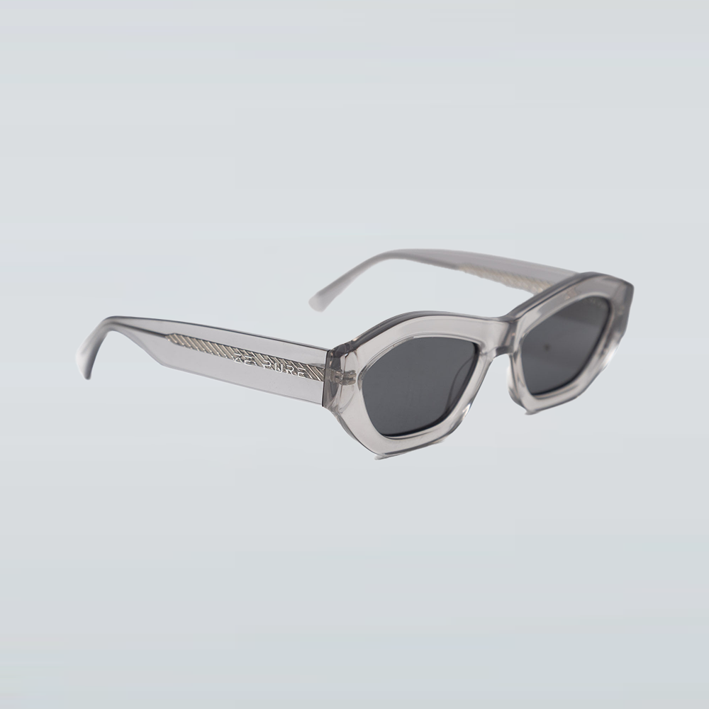 Sunglasses with clear frame and dark lenses on a light gray background