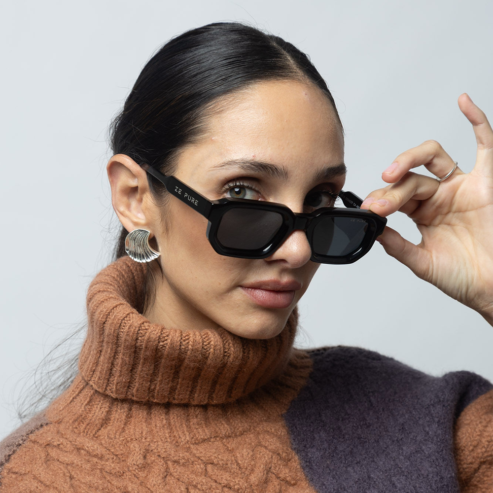 Woman wearing black sunglasses with a plain background