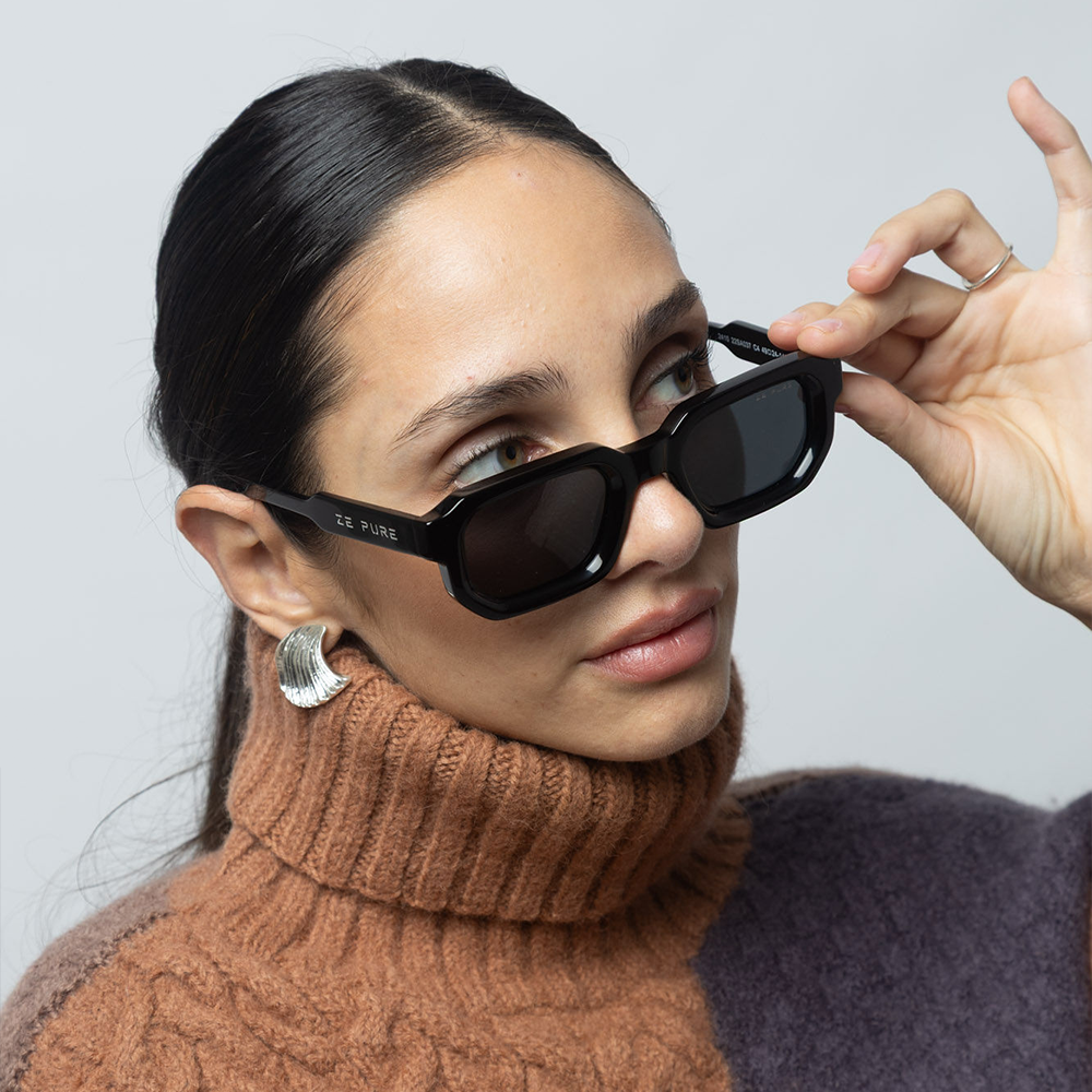 Woman wearing black sunglasses with a plain background